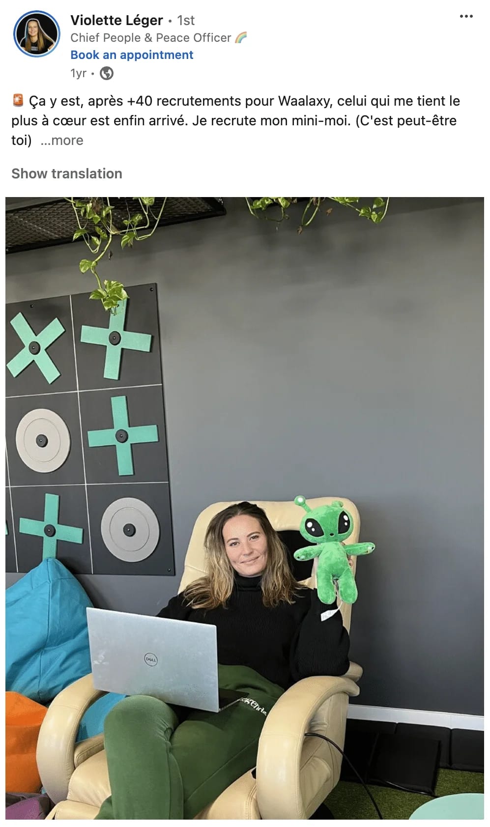 Femme travaillant sur ordinateur portable dans son salon avec décoration murale de disques et plantes suspendues